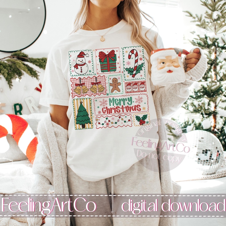 May include: White t-shirt featuring a colorful Christmas-themed design with a snowman, gift, candy cane, bells, gingerbread man, Santa faces, Christmas tree, and the words "Merry Christmas." A Santa mug is held in the hand.