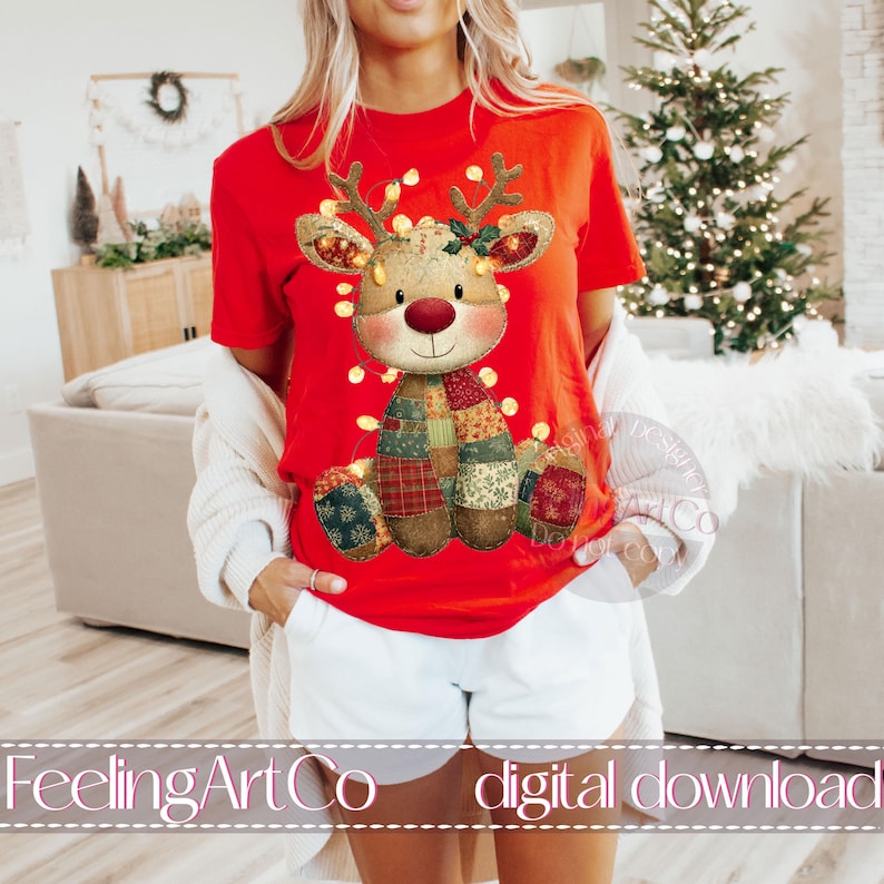 Puede incluir: Camiseta roja con un dise&ntilde;o festivo de reno. El reno tiene un cuerpo de retazos, una nariz roja y est&aacute; adornado con luces de cadena. El texto "FeelingArtCo digital download" est&aacute; en la parte inferior de la imagen.