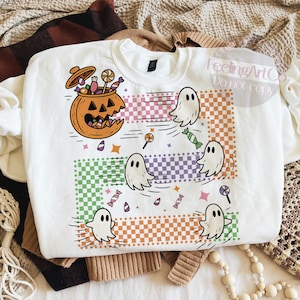May include: White sweatshirt with a Halloween-themed graphic. The design features a jack-o'-lantern filled with candy, cartoon ghosts, and colorful candy. The words "FeelingArtCo Do not copy" are in the top right corner.