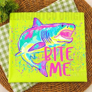 Op de afbeelding: Vierkante canvas print met een kleurrijke haaienillustratie in blauw, roze en groen, tegen een neongele achtergrond met verfspetters. De roze tekst luidt "BITE ME".