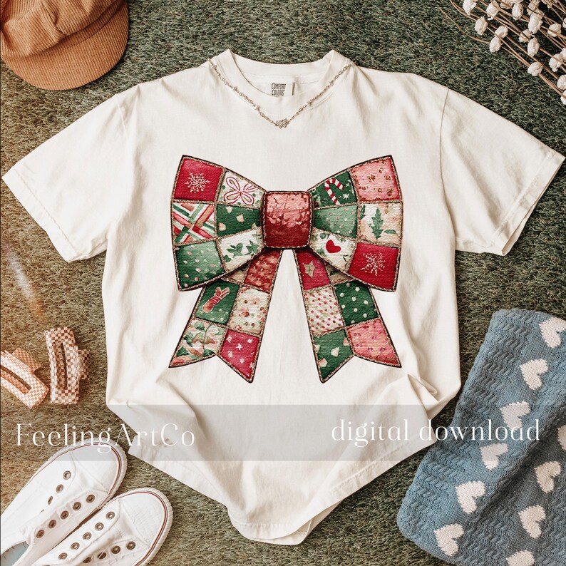 May include: A white t-shirt featuring a large, colorful bow design. The bow is composed of patchwork squares in red, green, and pink, with festive patterns. The text "Feeling ArtCo" and "digital download" are visible on the shirt.