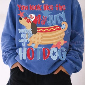 May include: Blue sweatshirt with a graphic of a hotdog dog wearing sunglasses and a hat, with the text "You look like the 4th of July" and "Hotdog". The design includes stars and the text "makes me want a".