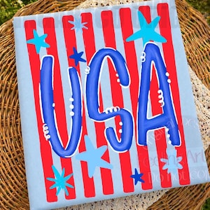 May include: A patriotic design with the word "USA" in blue, set against red stripes and a light blue background. The design includes blue stars, creating a festive feel. Ideal for celebrating national holidays.