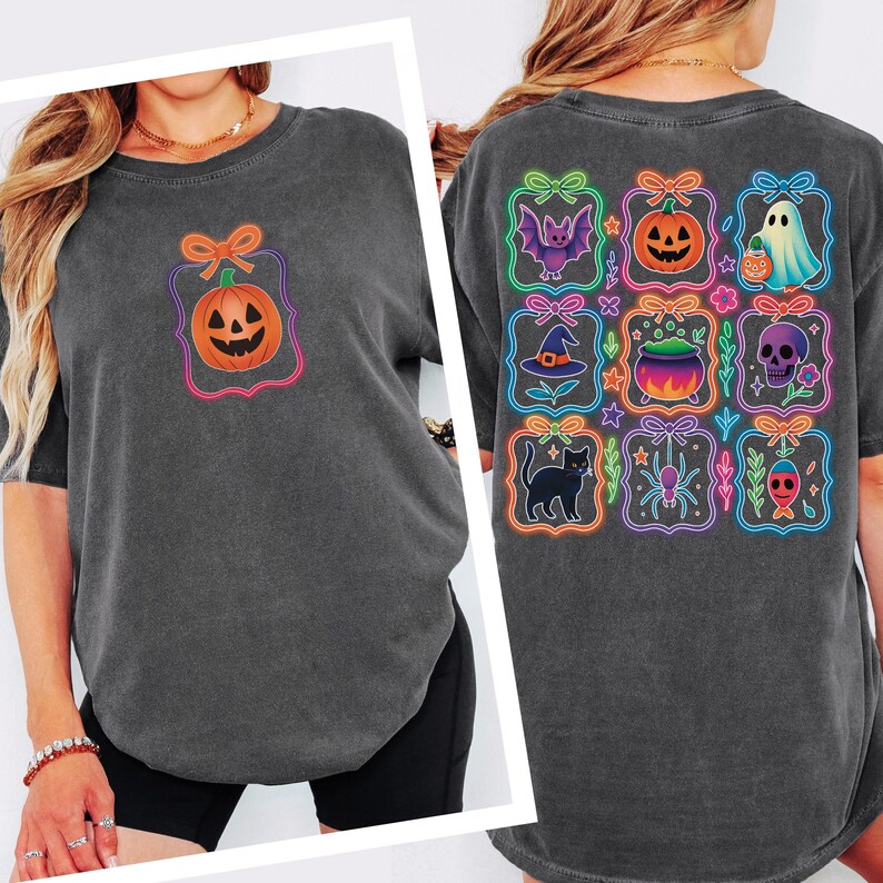 May include: Dark grey t-shirt featuring a Halloween-themed design. The front displays a pumpkin graphic, while the back showcases various Halloween icons like a bat, pumpkin, ghost, witch hat, cauldron, skull, black cat, spider, and a jack-o'-lantern.