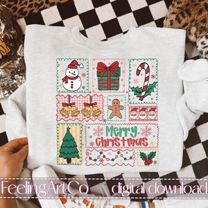 May include: Light gray sweatshirt with a colorful Christmas-themed design. The design includes a snowman, wrapped gift, candy cane, bells, gingerbread man, Santa faces, Christmas tree, and the text "Merry Christmas."