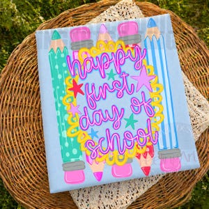 Puede incluir: Un letrero cuadrado de color azul claro con un marco festoneado amarillo central con el texto en rosa Happy first day of school. El dise&ntilde;o incluye ilustraciones de l&aacute;pices coloridos en turquesa, azul y rosa, con peque&ntilde;as estrellas.