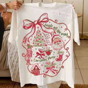 May include: White t-shirt with a festive Christmas design. The graphic includes a red bow, Christmas tree, Santa Claus, and the text "Jingle all the way" and "Christmas, Please".