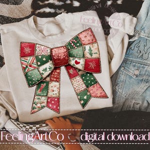 May include: A cream-colored sweatshirt featuring a large, patchwork bow design in red, green, and pink. The bow is decorated with festive patterns including snowflakes, hearts, and floral motifs. The text "FeelingArtCo digital download" is visible.