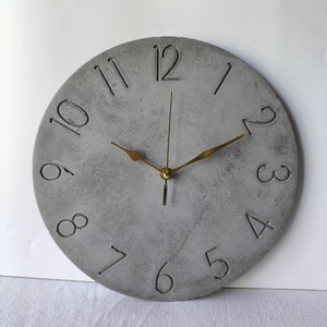 Horloge murale anthracite en béton : design minimaliste moderne avec aiguilles dorées