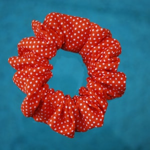 May include: A red and white polka dot scrunchie for hair.