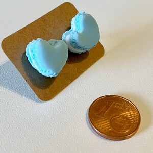 Könnte beinhalten: Ein Paar blaue herzförmige Makronen-Ohrringe. Die Ohrringe sind etwa so groß wie eine Ein-Euro-Münze.