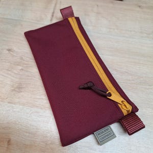 Pochette bordeaux avec fermeture éclair dorée