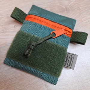 Mini pochette à fermeture éclair vert bronze avec fermeture éclair YKK orange et empiècement à boucle olive foncé.