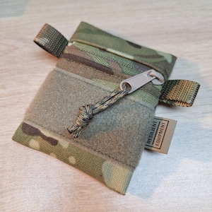 Multi Terrain Pattern Camouflage Mini-Tasche mit olivgrüner Schleife und olivfarbenem Futter.