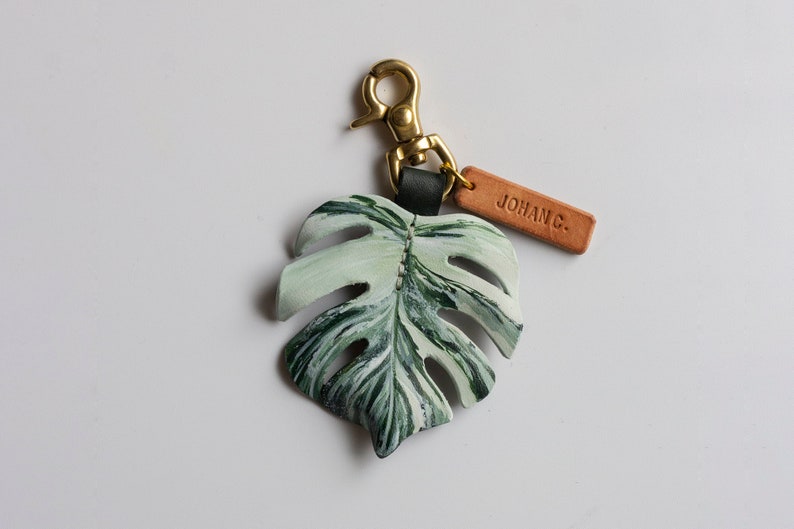 Monstera Deliciosa var Borsigiana 'Albo' Brokig läderväskeberlock, schweizerostväxtnyckelring, väsktillbehör med glänsande mässingsspänne bild 2