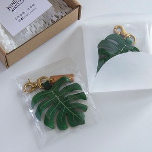 Monstera Deliciosa var Borsigiana 'Albo' Brokig läderväskeberlock, schweizerostväxtnyckelring, väsktillbehör med glänsande mässingsspänne bild 6