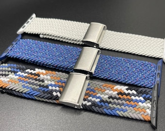 May include: Three braided Apple Watch bands in white, blue, and a multi-colored pattern with silver clasps.