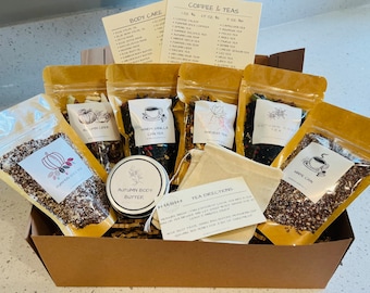 Könnte beinhalten: Eine braune Pappbox gefüllt mit einem Herbst-Geschenkset. Die Box enthält fünf Beutel mit losen Blättern, ein kleines Glas Körperbutter und einen Musselin-Teebeutel. Die Teesorten umfassen Pumpkin Spice, Autumn Cider, Warm Vanilla Chai, Harvest Tea, Autumn Chai und White Chai. Die Körperbutter ist mit "Autumn Body Butter" beschriftet. Der Teebeutel enthält Anweisungen zum Aufbrühen von Tee.
