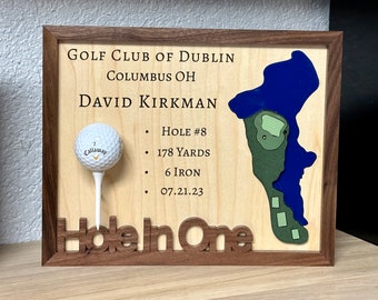 May include: A wooden plaque with a golf course map, a golf ball, and the text "GOLF CLUB OF DUBLIN COLUMBUS OH DAVID KIRKMAN HOLE #8 178 YARDS 6 IRON 07.21.23 Hole In One".