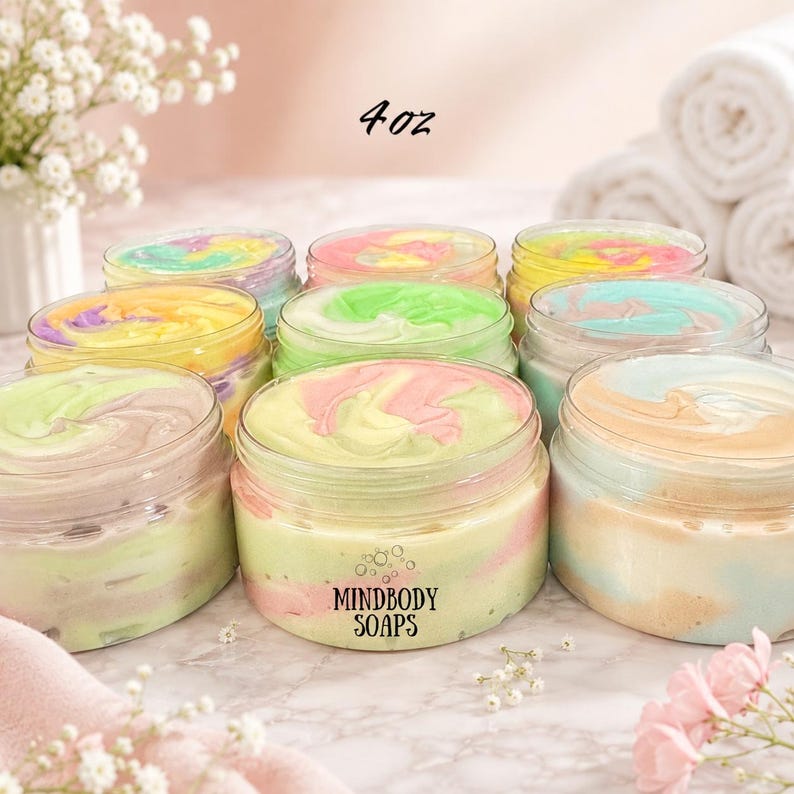 May include: A collection of 4 oz clear plastic jars filled with multi-colored swirled body butter or soap. The jars feature a label with the text MINDBODY SOAPS. The contents display various pastel color combinations including pink, green, yellow, and blue.