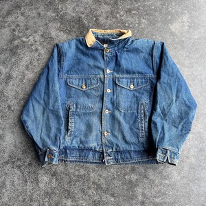 May include: A blue denim jacket with a tan corduroy collar. The jacket has two chest pockets, two side pockets, and button closures. The denim is faded, giving it a vintage look. The jacket is a classic style.