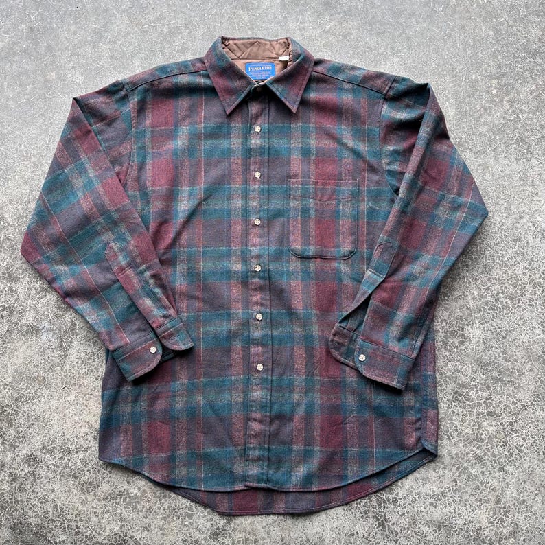 May include: A white ceramic mug with a black handle and the text "But First, Coffee" in a black, handwritten-style font. The mug is on a white surface.