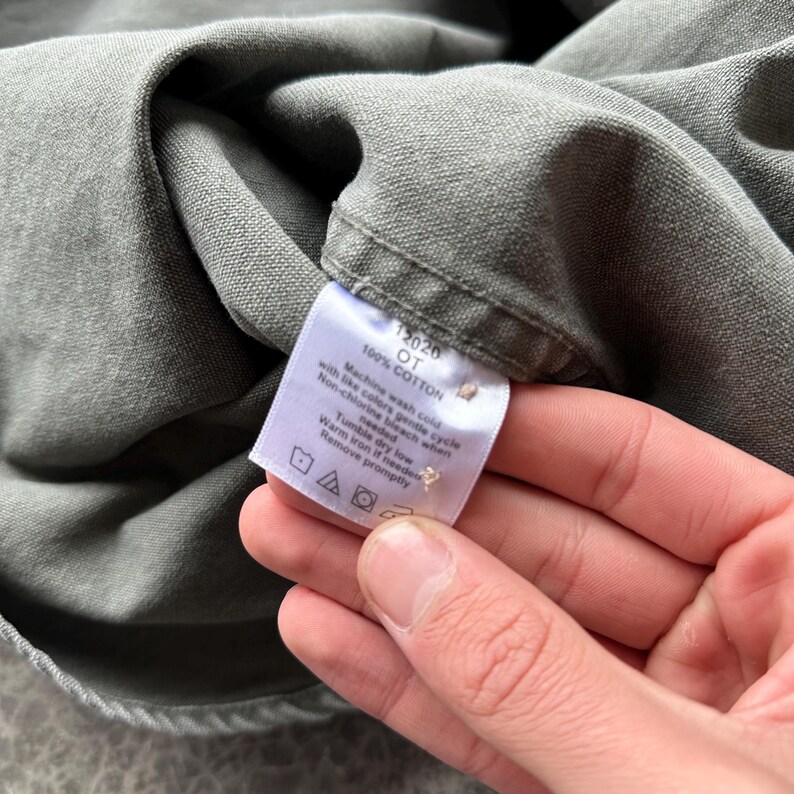 May include: A white ceramic mug with a black handle and the text "But First, Coffee" in a handwritten style. The mug is on a white surface. The mug is approximately 4 inches tall.