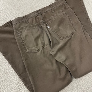 May include: A pair of brown corduroy pants with a back pocket and a small Levi's logo.
