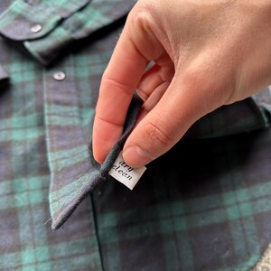 May include: A white ceramic mug with a black handle and the text "But First, Coffee" in a black, bold font. The mug is on a white surface. The mug is likely 11 ounces.