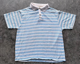 May include: A short-sleeved polo shirt featuring a textured grid pattern with horizontal stripes in light blue and white. The garment includes a solid white collar and a three-button placket at the neckline, providing a structured look.