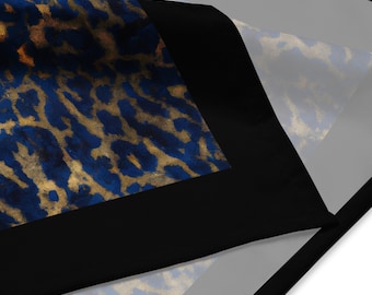 May include: A blue and gold leopard print fabric with a black border. The fabric is folded in half and the print is visible on both sides.