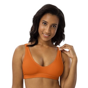 May include: A bright orange sports bra with a deep V-neck and thin straps.