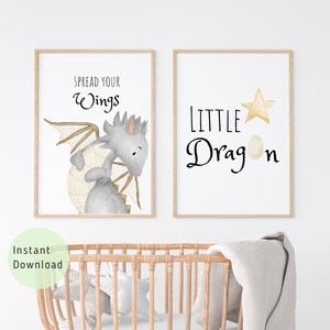 Könnte beinhalten: Zwei druckbare Kinderzimmer-Kunstdrucke mit einem niedlichen grauen Drachen mit braunen Flügeln. Der erste Druck sagt "Spread your wings" und der zweite Druck sagt "Little Dragon" mit einem goldenen Stern und einem Ei.