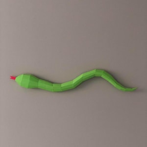May include: A green paper snake with a red tongue, crafted in a 3D style. The snake is curled in a S-shape, with its head on the left and tail on the right.
