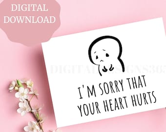 May include: A white card with black text and a simple cartoon drawing of a sad face. The text reads "I'm sorry that your heart hurts."