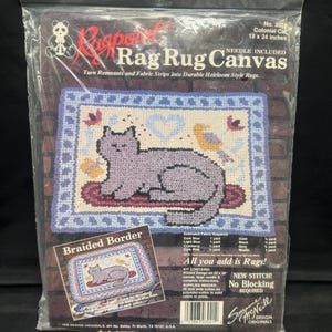 May include: A Rag Rug Canvas kit in a clear plastic package. The kit includes a printed design of a cat on a rug, with the text "Rag Rug Canvas". The rug measures 18 x 24 inches.