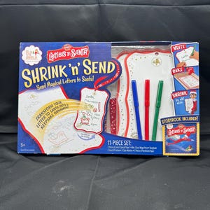 Novo conjunto de cartas mágicas para o Papai Noel com o novo elfo na prateleira Shrink 'n' Send e o livro 11