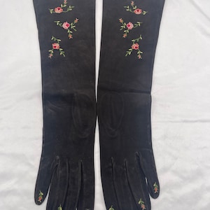 May include: A pair of long black gloves with delicate floral embroidery in shades of pink and green.