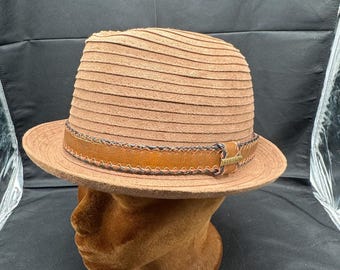 May include: A brown suede fedora hat with a leather band and stitching. The hat has a wide brim and a slightly rounded crown.