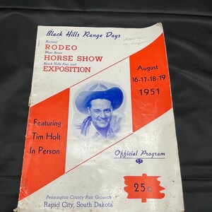 May include: A vintage program for the Black Hills Range Days Rodeo and Horse Show, featuring Tim Holt in person. The program is dated August 16-17-18-19, 1951, and costs 25 cents.