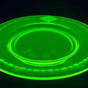 May include: A bright green glass plate with a beaded rim and the letters "LMD" in a diamond shape in the center.