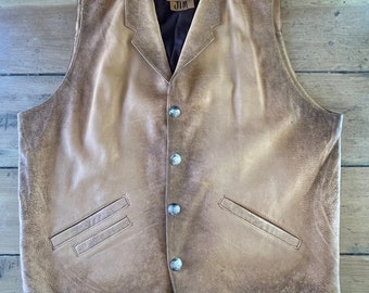 May include: A brown leather vest with a pointed collar and multiple silver buttons. The vest has two pockets on the front and a label on the front that says "JIM".