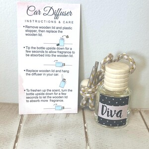 May include: A car diffuser with a wooden lid and a label that says "Diva". The diffuser is in a small glass bottle with a black and white pattern. Instructions for use are on a pink card.
