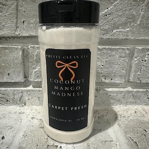 May include: A clear plastic container with a black lid, filled with white powder. The label reads "Pretty Clean LLC" with "Coconut Mango Madness Carpet Fresh" in white text on a black background. The container is 16 oz.