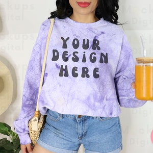 Może przedstawiać: Fioletowa bluza z nadrukiem tie-dye z napisem "YOUR DESIGN HERE" w kolorze czarnym. Bluzę nosi osoba trzymająca szklankę pomarańczowego soku ze słomką.