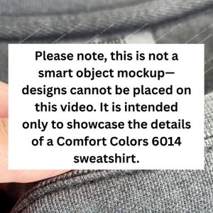 May include: A close-up of a gray Comfort Colors 6014 sweatshirt. The image includes a white rectangle with black text that reads: "Please note, this is not a smart object mockup&mdash;designs cannot be placed on this video."