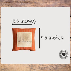 May include: A small orange and white pillow with the text "HAPPY thanksgiving" on it. The pillow is 5.5 inches by 5.5 inches and has a handmade label.