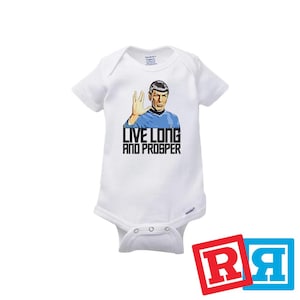 May include: White baby onesie with a graphic of Star Trek's Spock with the Vulcan salute and the text "Live Long and Prosper".