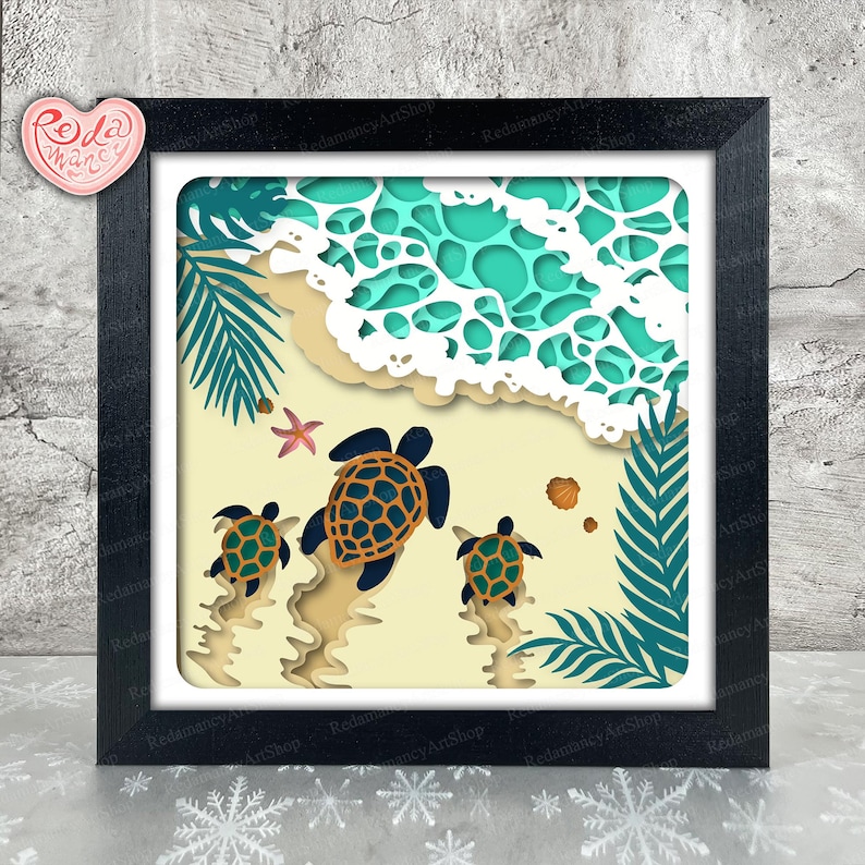 May include: A framed paper art piece showing a beach scene with three turtles heading towards the sea. The artwork uses layers of paper in blue, green, beige, and white, creating a 3D effect. A starfish and seashells are also visible.