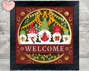 May include: A red, gold, and green papercraft Christmas sign with a welcome message. The sign features a circle with a wreath, snowflakes, and three gnomes holding gifts.